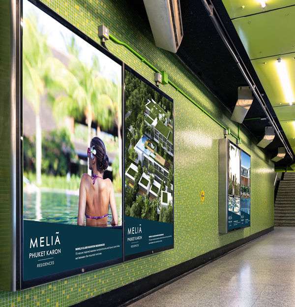 Large posters on a wall promoting Phuket property.